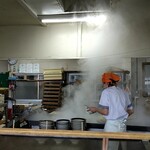 牧のうどん - 調理場（うどん湯掻き中）※上の2本の線で製麺機ON･OFF切り替えされてました。細長い釜に左側から自動投入される仕組み