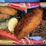 スーパーセンタートライアル - ご飯の上には焼き海苔、きんぴら牛蒡、ソースが良く染みた白身魚のフライ、ポテトコロッケ、唐揚げ、竹輪磯辺揚げ、だし巻き卵、赤ウインナー、焼きそば入り。