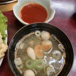 ファミリーハウス みちのく - 麩とワカメの味噌汁、赤いのは唐揚げ用のチリソース