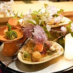 銀座 しのはら - 八寸：京都大原の筍と木の芽田楽、黄にら鴨ロース巻き、子持ち昆布、赤こんにゃく、細魚鮨、せんまい、松の実をまぜた衣で揚げた白海老の真丈白エビ、サクラマス、イイダコと菜の花を蛤の器で 、イカ、ネギのぬた和え青竹の器で、大根で巻いた灯篭