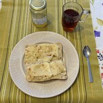 Trattoria Perla Cafe - この日、遅く起きてきた孫娘が自分で作った朝食 (温めたパーネに乾燥オレガノを塗してオリーブオイル、チーズを加え、もう一度温めたもの)、蜂蜜入り紅茶