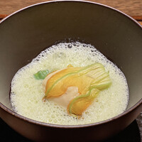 デンクシフロリ - 豆 花ズッキーニ
                    花ズッキーニの中には帆立の真薯、グリーンピースの温かな摺流しのスープ、これは美味しい！
                    真薯がハンペンの様にフワッフワ、その甘みがグリーンピースの摺流しの甘みと重なりいい味わい♪