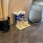 麺や 麗 - 机上の調味料は粗挽ブラックと一味唐辛子とおろしニンニク。