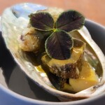 白土 - 柔らかい蝦夷鮑、あわび茸のフリットに肝ソースがかかった一品。食用の三葉のクローバーが飾られています。