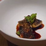 白土 - 炭火だ香ばしく焼かれた鰻。ソースは中華のよだれ鶏のタレです。木の芽と獅子唐が添えられています。