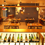 キッチンミルポワ - ワイン棚越し店内。天井も高く空間も広々なのでコロナにも安心です。貸切予約はテーブル、椅子が自由に移動でき、ご要望にも柔軟に対応可能です。お気軽にご相談ください。