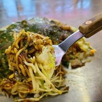 Okonomiyaki Yurichan - 甘さ控えめなミツワソースに半熟玉子が絡んでコクと旨みが加わり、良い感じ
                        麺はモチッとした食感、バランスが取れていて広島らしいお好み焼きです