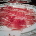 バー クラスター - 【超熟成生ハム】 美しいピンク色が、白い皿を華やかに彩り、まるで桜が咲いたようだ