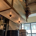 sio - 店内の風景写真。厨房と客席の間にあるカウンター上の照明。温かい感じの色合い