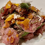 f - 軽く焼いて香りを立たせた蕨と虎杖を秋田錦牛と和えてチーズとポテトチップスを食感のアクセントに加え細かくしたチーズとオクラを散りばめてあります