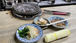 元祖　京城屋 - 七輪とタレ、おしぼりと箸とトングがセットされ、、お通し(150円税別)のキムチとナムルが来ました。