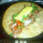 エルボラーチョ - 名物料理パストール。トルティーヤ生地に豚肉、パイナップル、パクチーを載せたもの。特徴的な味わいがうまい！