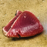 鮨おばな - ルビー色に煌めくのは鰹。切り分けてから皮目を藁で炙ります。ほのかな草の香りが食欲をそそります