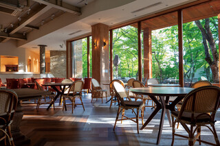 Cresson River Side Story - View from the restaurant interior, overlooking the terrace seating and moss garden.