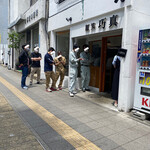 麺笑 巧真 - JR八王子駅で途中下車して、小走りと速歩きで
      
      『麺笑　巧真』さんの前まで行くと
      
      やっぱり並んでいる…でも、割と少なめ…
      
      コレはラッキーな展開！