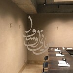 ビリヤニ大澤 - 入口の窓　ウルドゥー語のロゴ　「ビリヤニ 大澤」と書いてあるそうです　デザイン性がすごい　ビリヤニから立ち昇る湯気や香りにも見える