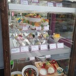 Cats Cafe - 入口前のショーケースに並んだ、いかにもチェーン店な食品サンプルメニュー。 そこはかとなく漂う昭和デパートのレストランの空気に「完全想定範囲内」を予感しなくも…  まぁいい。パフェだパフェ！