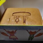 Floche Mama - パッケージ箱の下部から撮るときつねさんがお皿に載ったカステラを持ち上げているようですね(=^ェ^=)