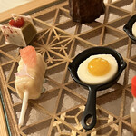 Amandier - 左奥から時計回りにピスタチオ豆腐、カヌレ、目玉焼きがココナッツムースとマンゴーピューレ、グレープフルーツのアイスのホワイトチョコ包み