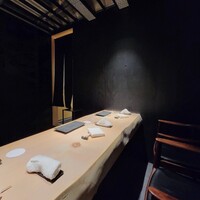 鮨 梢 - 黒を基調とした店内に白木のカウンター