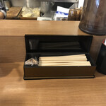 鯛塩そば 灯花 本店 - 左に手指消毒アルコール、真ん中の左に爪楊枝、真ん中の右に割り箸、右におしぼり、右上にお水