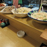 春のお店 - カウンターには大皿料理が並びます