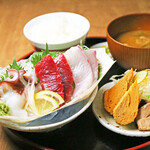 Large wooden boat platter of sashimi and Kyoto-style dashimaki set meal