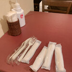 タパス＆タパス - レジ脇の席に座り注文品の出来上がりを待ちます　卓上に置いてあるのはテイクアウト用のフォークとお手拭き　年明けからセルフテイクになりました