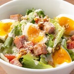 Caesar salad with half-boiled eggs and bacon