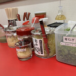 とんこつラーメンいしい - 充実の卓上（青ネギ無料）