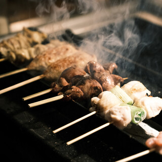 Yakitori (grilled chicken skewers) grilled over charcoal