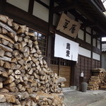 草庵 - 入り口の両側に沢山の薪が置いてあります。