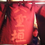 八重垣 - 暖簾から顔を出したママ