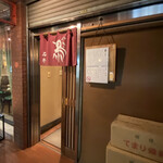 石井 - 海老茶の暖簾と備長炭の箱が目印