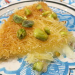 アラブ料理専門店 七つの丘 SEVEN HILLS - クナーフェ "Kunafeh"「アラブ世界で広く食べられている人気のスイーツ。小麦粉の生地にチーズを挟んで焼き、ナッツを振りかけていただくあたたかいデザート」※メニュー表記通り