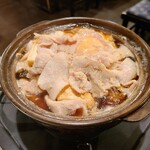 長八 - 肉豆腐（完成形）　豆腐と生の豚肉、生卵が入った土鍋を卓上で煮込むスタイル
