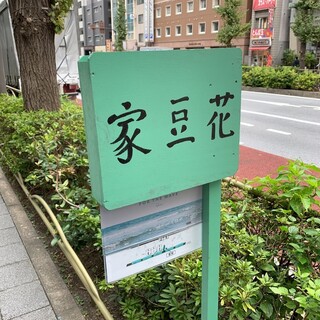 家豆花 - 歩道脇の植え込みに立てられたお店の看板