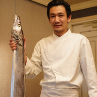 六花 - 俗に「ドラゴン」とも呼ばれる巨大な太刀魚を手にする佐藤シェフ。