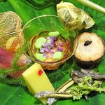 草喰 なかひがし - 八寸：透かしほおずき 卵黄の味噌漬を挟んだ銀杏、玉蜀黍の寒天、酢飯を詰めた茗荷の酢漬け、無花果と枝豆のきな粉酢和え、ごり、味女、ウドの花、のし梅を挟んだ里芋、キハダ、鮎のテリーヌを包んだ花オクラ