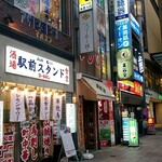 立ち呑 ちとせ - 雑居ビルの表側は賑やかな看板がところ狭しと…