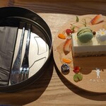 きんじろう CAFE&GRILL - かわいいケーキ。ケーキの下にナイフとフォーク、お手拭きを内蔵。周りのお花と果物でプラス200円。