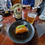 もつ焼 まるい - ビールは赤星、お通しは大根の煮物