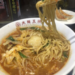 大阪王将 - 牛モツラーメンの麺リフト、中央に牛モツ