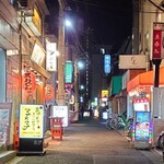 鳥椿 - 商店街から見た路地　右に晩杯屋　左にかぶら屋さんがあってわからないが左側の奥に鳥椿さんがある