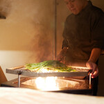 膳処末富 - 始まりを告げるように空芯菜が燻し焼かれます。