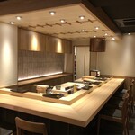 Asabu Juuban Sushi Tomo - 暖かい木目と照明のコントラストを基調とした落ち着いた空間。