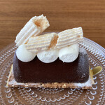 Un Petit Paquet - シェフのきまぐれ　ラム酒を効かせ、ほんのりオレンジの香りをつけた口溶けの良い蒸し焼きチョコレートをカカオニブ、アーモンド入りのクッキーを重ねました