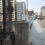 発酵×リゾットの店 リゾーラ - 橋の向こうにお店のblueの看板.