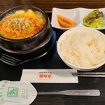 韓味家 - 純豆腐チゲ(税込900円)
            玉子&榎茸&豆腐&刻み葱&浅蜊1個、チゲスープ
            白ご飯、トマト2切れ、グリーンレタス少々が付く
            グツグツと煮立った状態で提供されます
            白ご飯は硬くて少しダマになってます