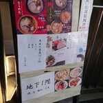 麺処 三虎 - 地下へ潜る手前の看板。ラーメンののぼりが目印